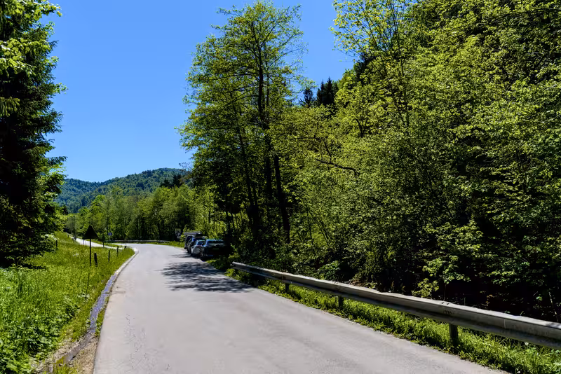 The main road with some parked cars next to it in the distance.