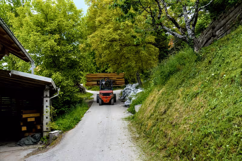 A forklift moving a stack of wood around at the Žaga Dolenc sawmill.